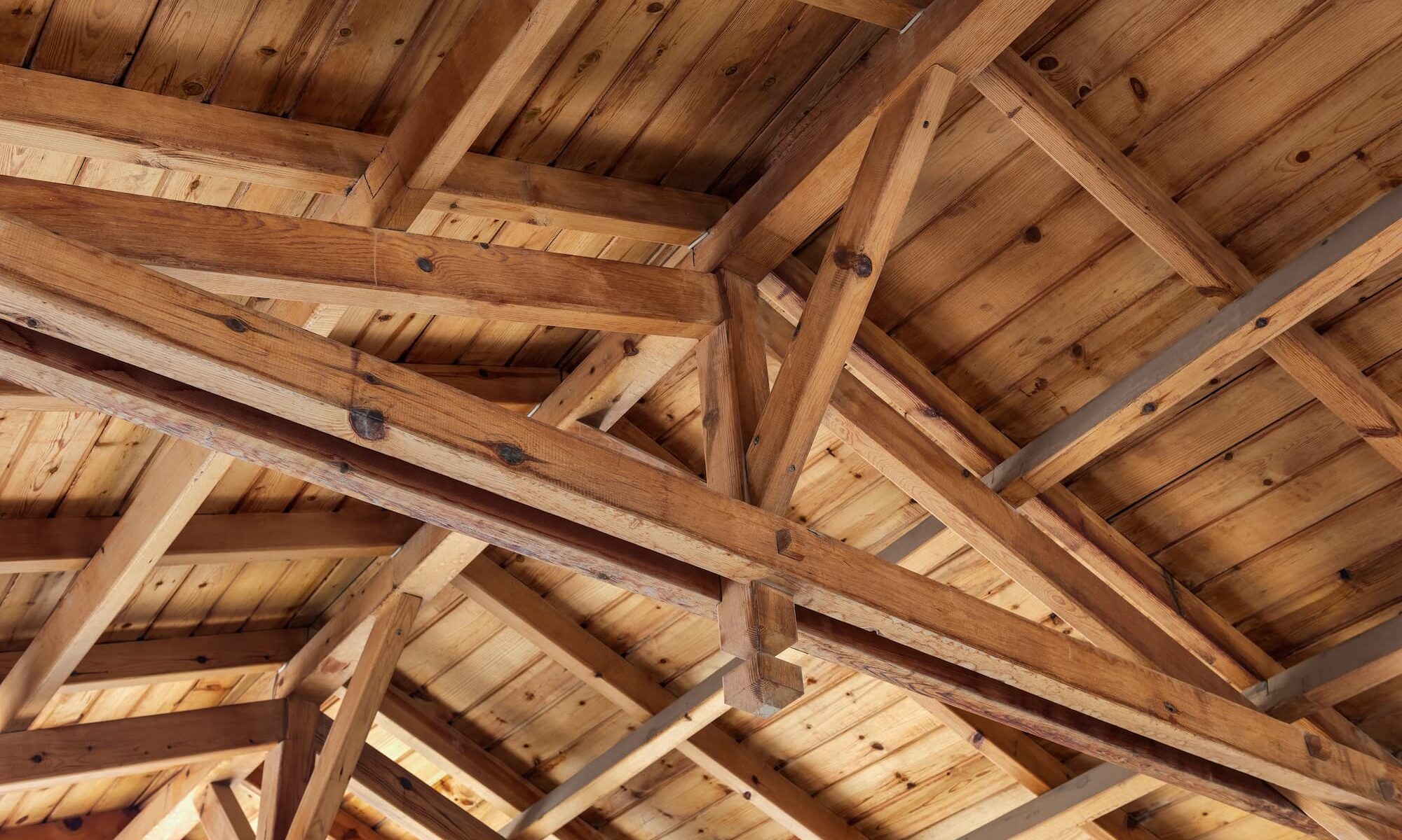 Les toits se chevauchent. Structure du toit de l'intérieur. Poutres en bois, rafteurs et joies.