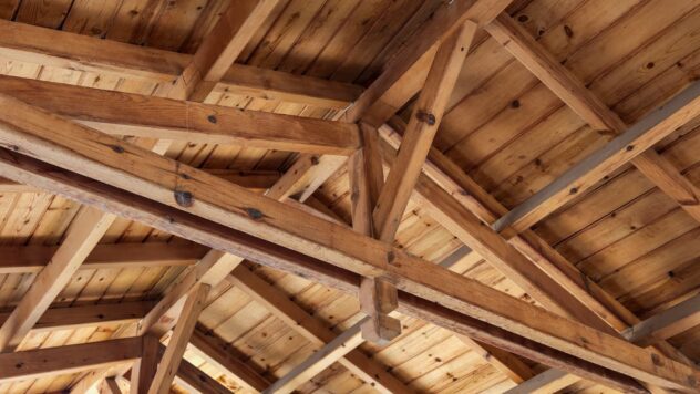 Les toits se chevauchent. Structure du toit de l'intérieur. Poutres en bois, rafteurs et joies.