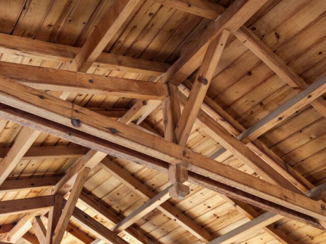 Les toits se chevauchent. Structure du toit de l'intérieur. Poutres en bois, rafteurs et joies.