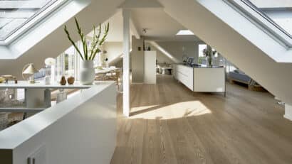 Grenier spacieux avec plafond en pente et fenêtres de toit VELUX, décoration moderne.