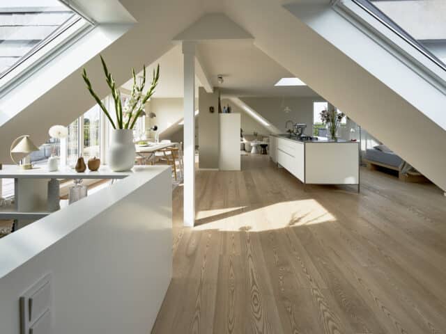 Grenier spacieux avec plafond en pente et fenêtres de toit VELUX, décoration moderne.