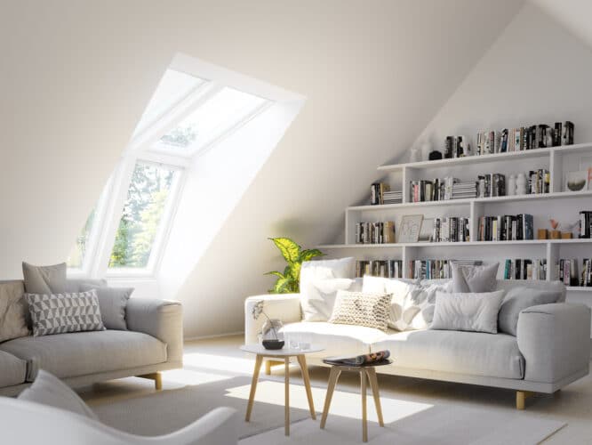 Salon mansardé avec plafond incliné et fenêtre de toit VELUX, lumière naturelle.