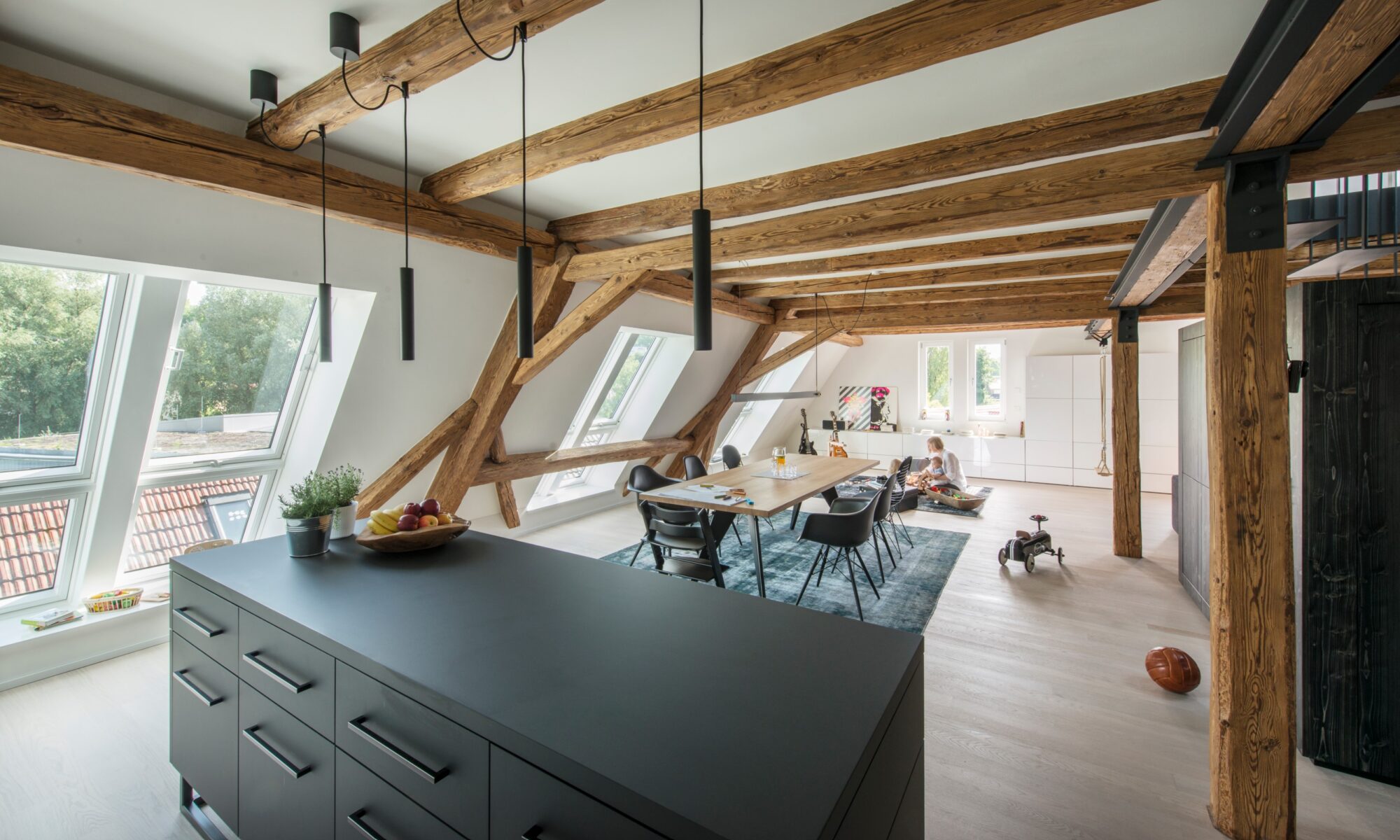 Salon sous combles atypiques avec des poutres apparentes.