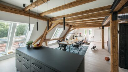 Salon sous combles atypiques avec des poutres apparentes.