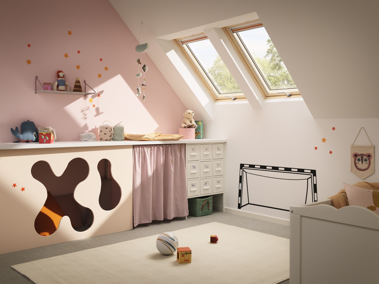 Chambre pour bébé aménagée sous les combles avec une fenêtre VELUX.