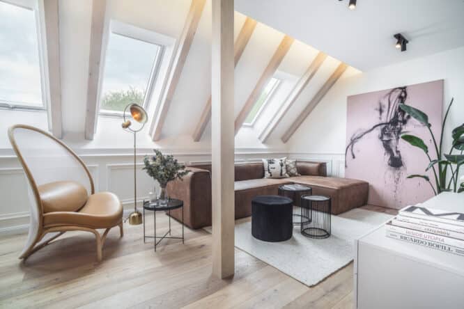 Salon mansardé avec plafond en pente, fenêtres de toit VELUX, mobilier moderne.
