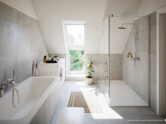 Salle de bain avec plafond en pente et fenêtre de toit VELUX, équipements modernes.