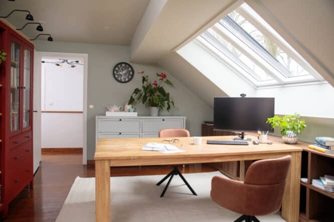Bureau à domicile mansardé avec plafond en pente et grandes fenêtres de toit VELUX.