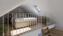 Chambre mansardée avec plafond en pente et fenêtre de toit VELUX, baignée de lumière naturelle.