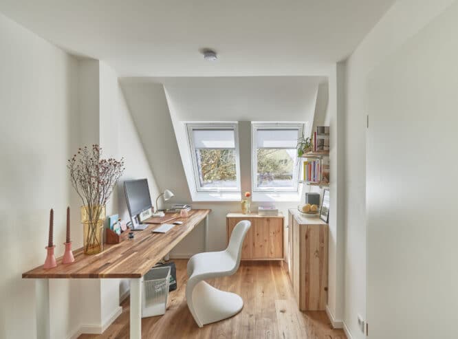 Bureau mansardé avec plafond incliné et fenêtres de toit VELUX, lumineux et confortable.