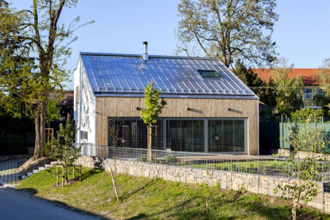 Maison moderne avec toit métallique et fenêtre de toit VELUX. 