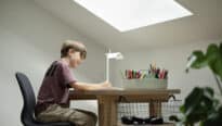 Enfant attablé à son bureau sous pente