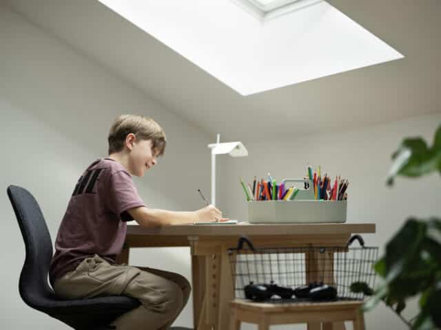 Enfant attablé à son bureau sous pente