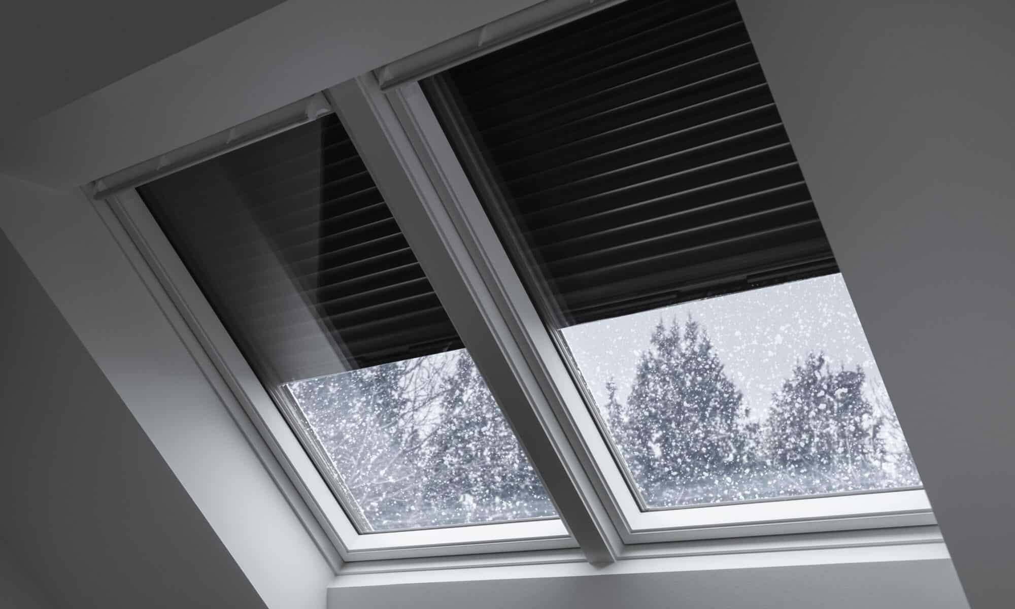 Toit enneigé avec fenêtres de toit VELUX et volet roulant solaire.