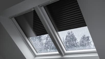 Toit enneigé avec fenêtres de toit VELUX et volet roulant solaire.