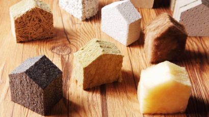 Plusieurs isolants naturels découpés en forme de maison et déposés sur une table.
