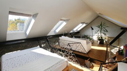 Espace de vie sous combles avec plafond en pente et fenêtres de toit VELUX, mobilier moderne.