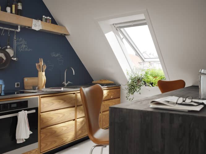 Cuisine mansardée avec plafond en pente et fenêtre de toit VELUX ouverte.
