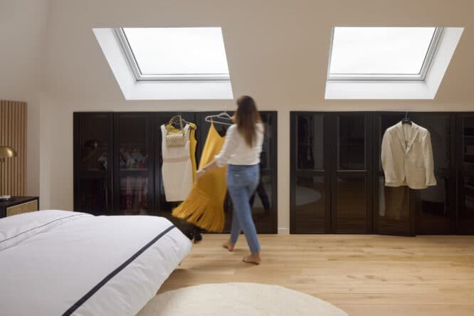 Rangement sous les pentes d'une chambre sous comble avec de grandes fenêtres de toit VELUX