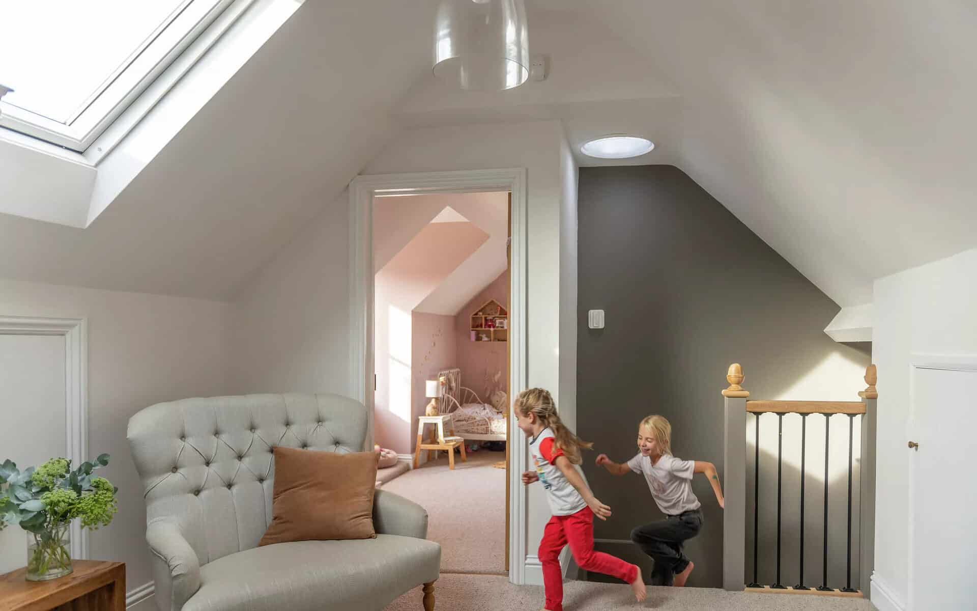 Conduit de lumière donnant sur une pièce mansardée.