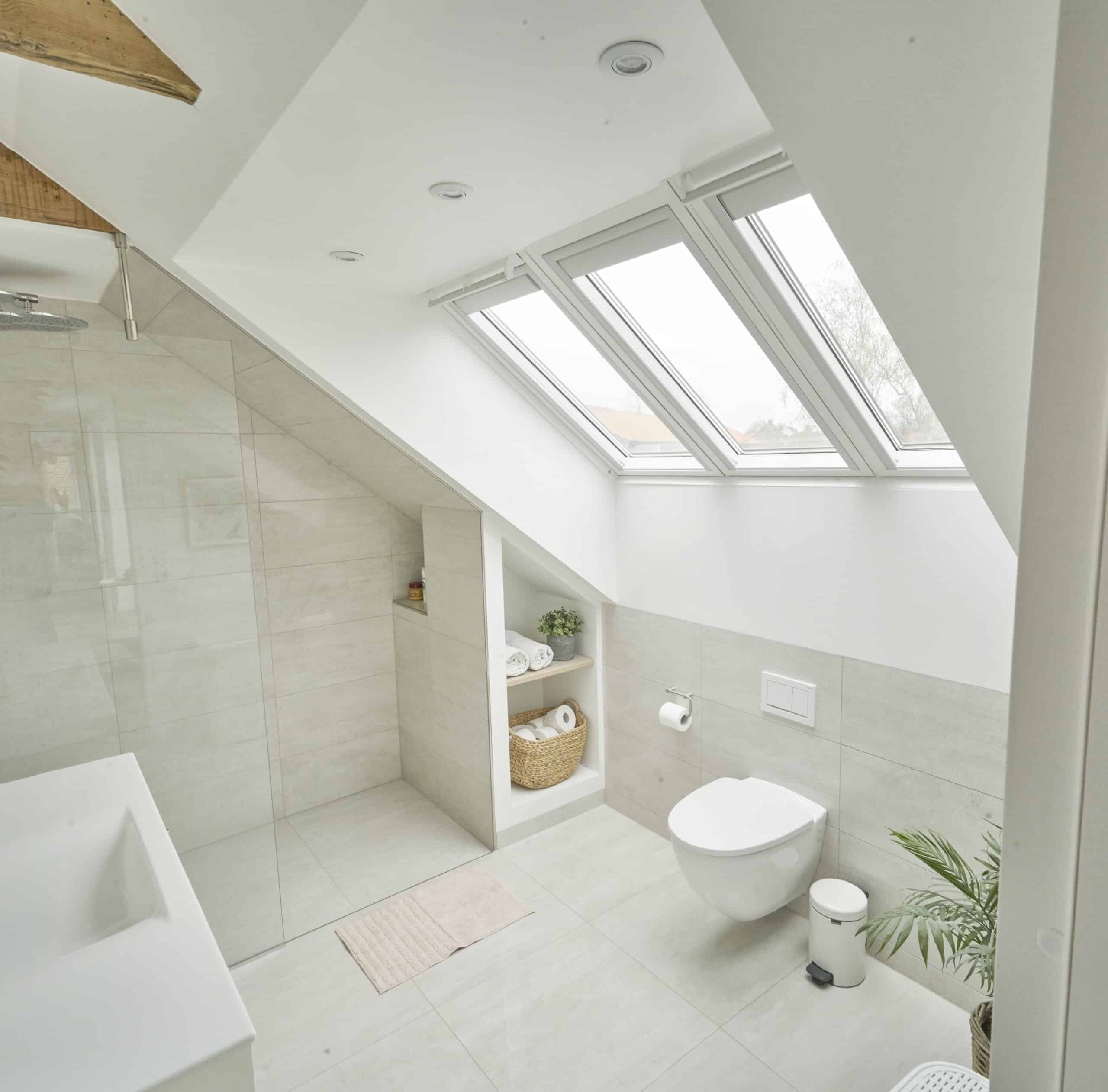 Douche sous pente avec receveur plat sous combles avec plafond en pente et fenêtres de toit VELUX, au design moderne.