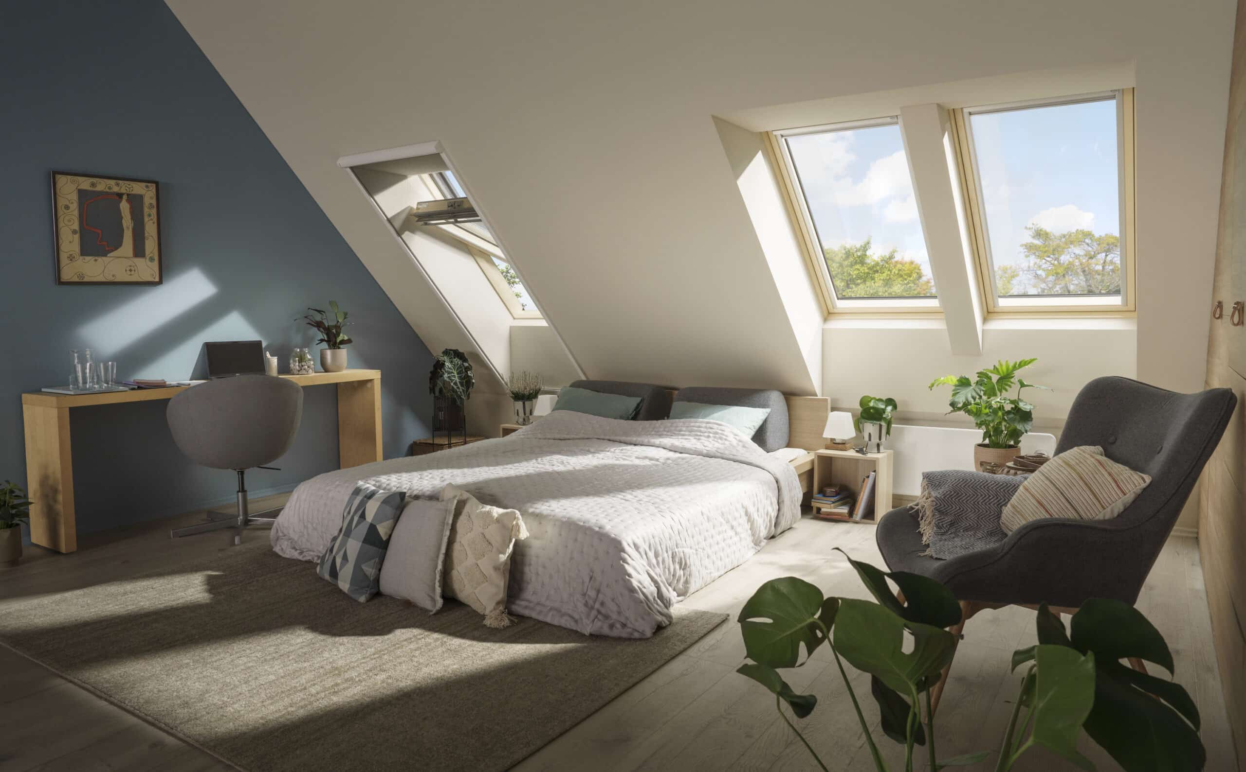 Chambre sous combles avec plafond en pente et fen&ecirc;tres de toit VELUX, d&eacute;coration chaleureuse.