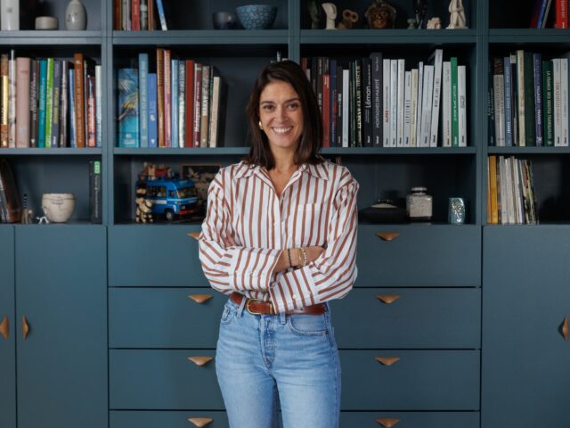 Ophélie Prinet debout devant une bibliothèque