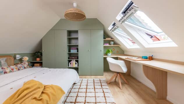 Chambre sous comble avec de grandes fenêtres de toit et un meuble sur mesure vert sauge.