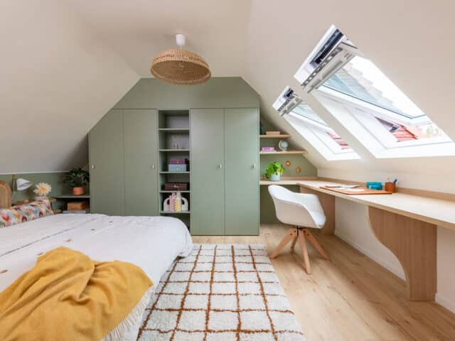 Chambre sous comble avec de grandes fenêtres de toit et un meuble sur mesure vert sauge.