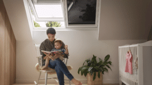 Une femme lit un livre à son bébé, assise sur une chaise