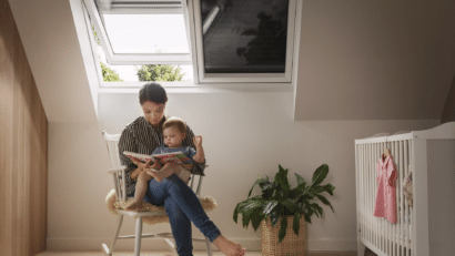 Une femme lit un livre à son bébé, assise sur une chaise