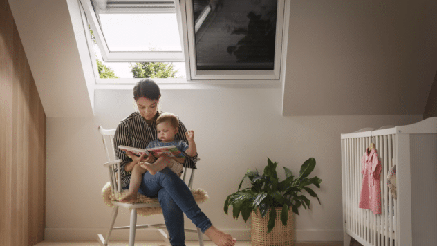 Une femme lit un livre à son bébé, assise sur une chaise
