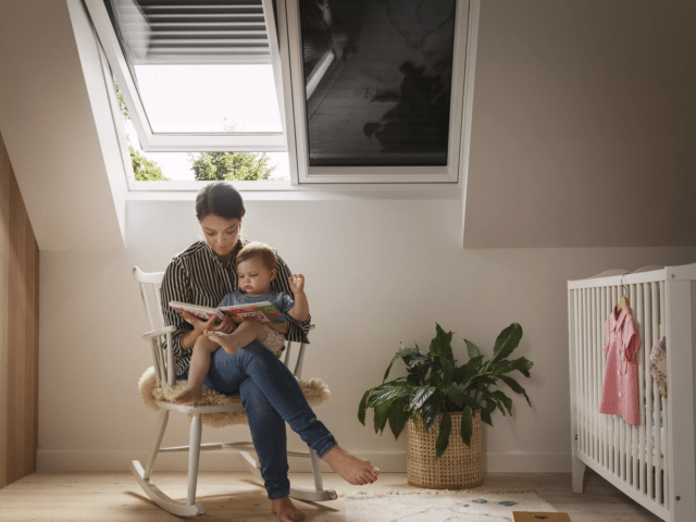 Une femme lit un livre à son bébé, assise sur une chaise