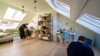 Chambre d'enfants mansardée avec plafond en pente et fenêtres de toit VELUX, lumineuse et ludique.
