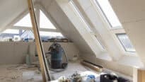Grenier en cours de rénovation avec plafond en pente et fenêtres de toit VELUX.