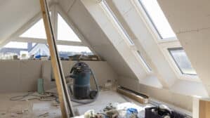 Grenier en cours de rénovation avec plafond en pente et fenêtres de toit VELUX.