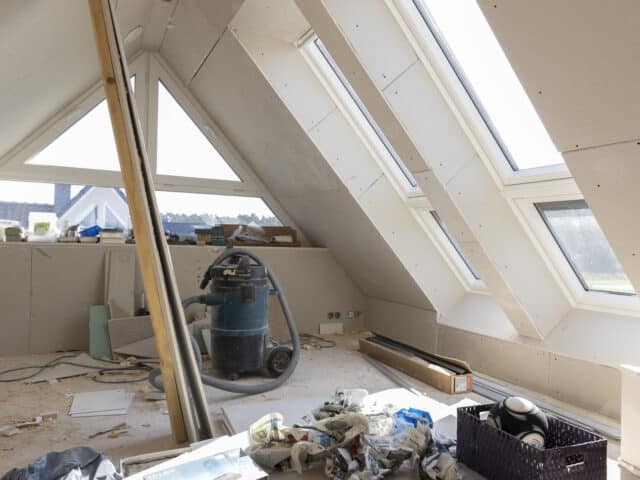 Grenier en cours de rénovation avec plafond en pente et fenêtres de toit VELUX.