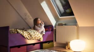 Chambre d'enfant mansardée avec plafond incliné et fenêtre de toit VELUX, décoration chaleureuse.