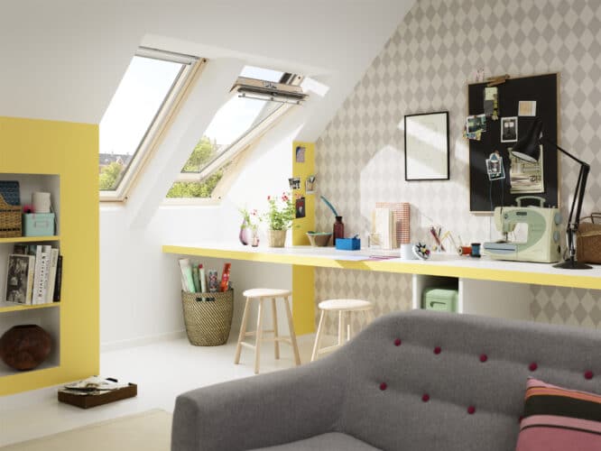 Pièce de loisirs mansardée avec fenêtre de toit VELUX, machine à coudre et matériel de bricolage.