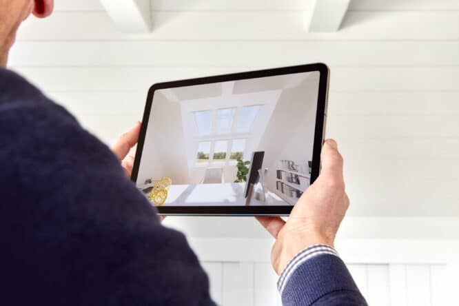 Tablette présentant un aménagement de combles avec une fenêtre de toit VELUX et un mobilier moderne.