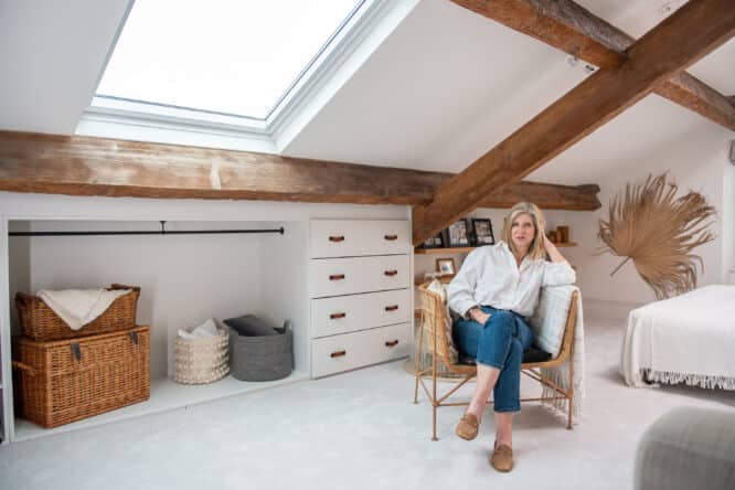 Chambre mansardée avec plafond en pente, fenêtre VELUX et décoration chaleureuse.