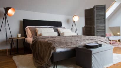 Chambre mansardée avec plafond incliné et fenêtre de toit VELUX, confortable et accueillante.