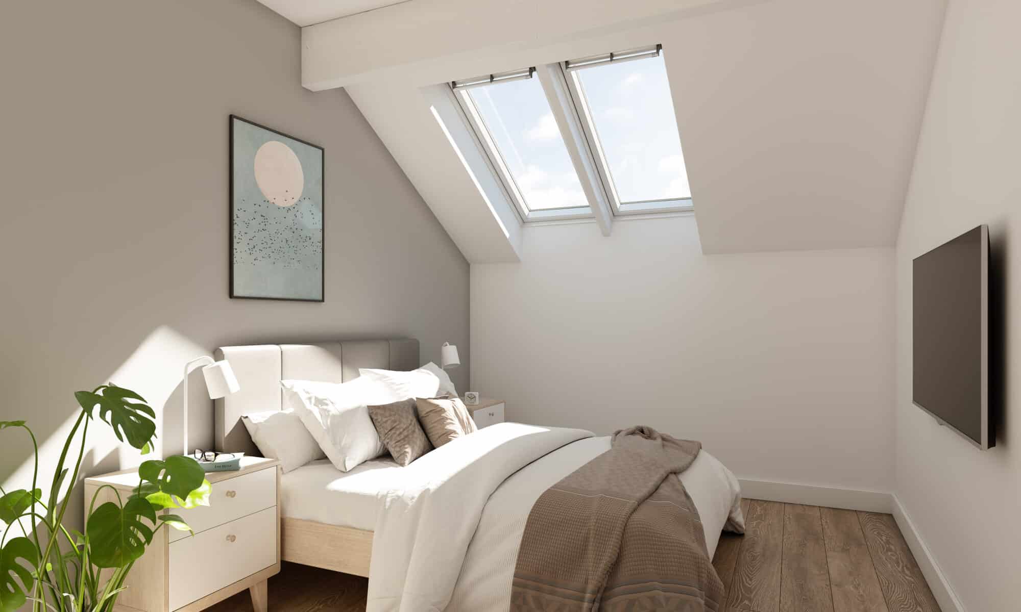 Chambre mansardée avec plafond incliné et fenêtres de toit VELUX, laissant entrer la lumière naturelle.