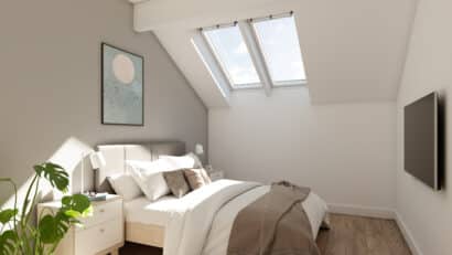 Chambre mansardée avec plafond incliné et fenêtres de toit VELUX, laissant entrer la lumière naturelle.