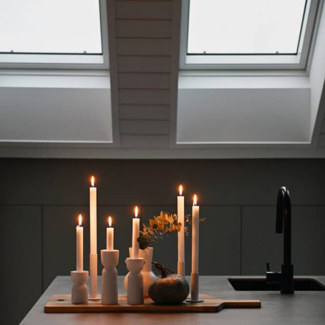 Plan de travail de cuisine avec bougies allumées, plafond en pente et fenêtres de toit VELUX.