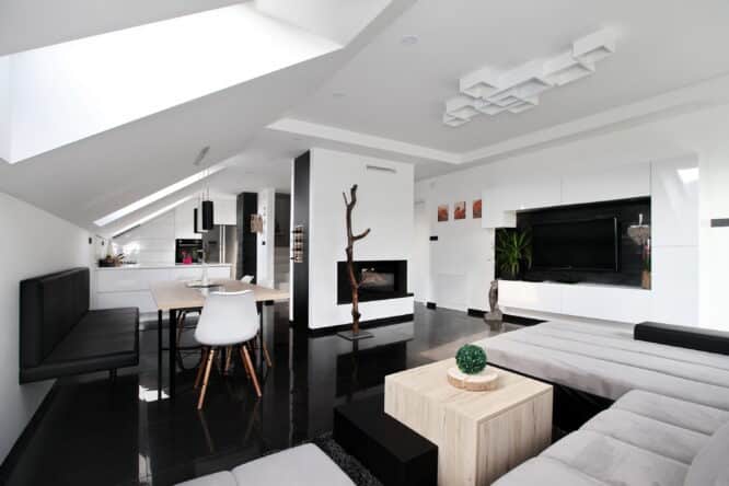 Espace de vie moderne sous les combles avec plafond incliné et fenêtres de toit VELUX.