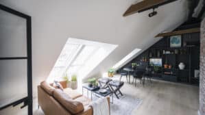 Espace de vie mansardé avec plafond incliné, fenêtres de toit VELUX et décoration moderne.