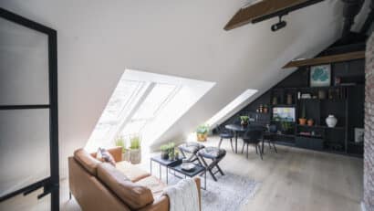 Espace de vie mansardé avec plafond incliné, fenêtres de toit VELUX et décoration moderne.