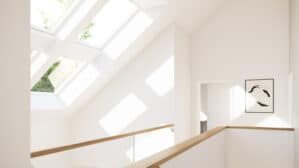 Palier mansardé avec plafond incliné et plusieurs fenêtres de toit VELUX laissant entrer la lumière naturelle.