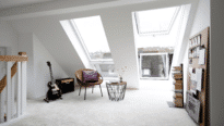 Pièce mansardée avec plafond en pente et fenêtres de toit VELUX, espace lumineux et aéré.